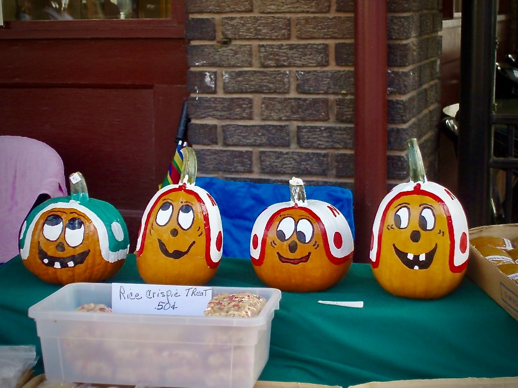 Hand-painted decorative pumpkins with smiling faces at a Haymarket market booth